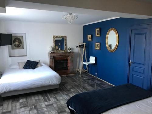 a blue room with a bed and a mirror at L'hostellerie de Sèvremont in Saint-Michel-Mont-Mercure