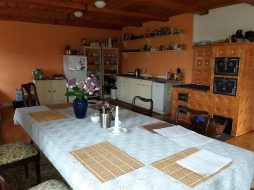 a kitchen with a table with a blue table cloth at Chalupa Anadělská Hora in Andělská Hora