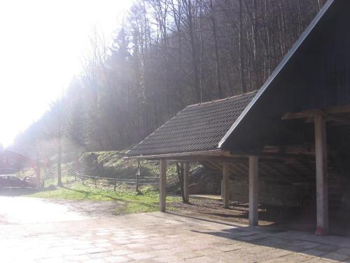 a wooden pavilion with trees in the background at Apartments Gubanec in Cerklje na Gorenjskem