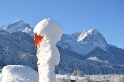 a pole covered in snow with mountains in the background at Hotel Vier Jahreszeiten in Garmisch-Partenkirchen