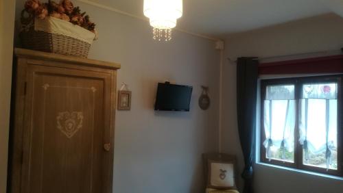 a room with a door and a television and a window at La Gerbaudiere Chambres&Table d hotes proche Mont Saint Michel CUISINE MAISON in Notre-Dame-du-Touchet