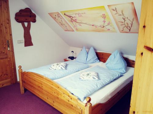sypialnia z drewnianym łóżkiem z niebieską pościelą w obiekcie Gästehaus Hobelleitner w mieście Sankt Blasen