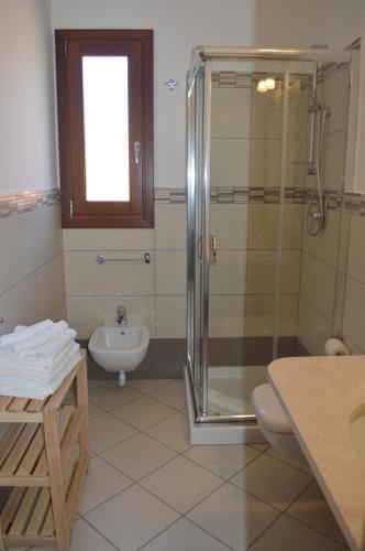 a bathroom with a shower and a toilet and a sink at Guest Rooms Affittacamere in San Teodoro