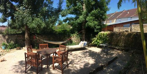 a hammock in a backyard with a dog sleeping on a table at Chambres d Hôtes Les Filles Tresy in Passenans