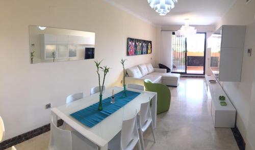 ein Wohnzimmer mit einem weißen Tisch und einem Sofa in der Unterkunft Modern Ground Floor Calanova Golf Apartment in La Cala de Mijas