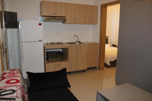 a kitchen with a refrigerator and a couch in a room at Le Caravelle Beirut in Beirut
