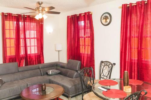 a living room with red curtains and a couch at Frontline Apartments in Christ Church
