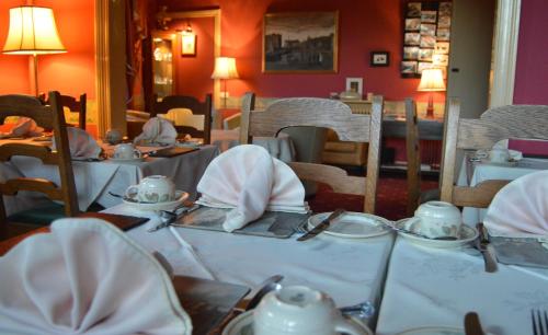 un comedor con mesas y sillas con mantel blanco en A-Haven Townhouse Hotel, en Edimburgo