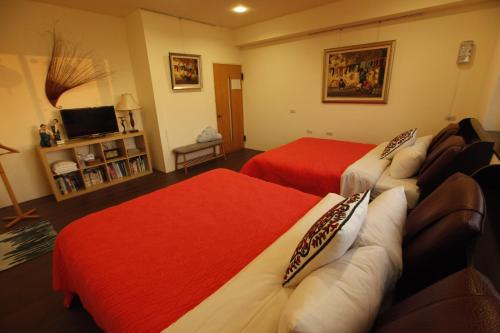 a hotel room with two beds and a television at Taichung Xinshe Garden Life Homestay B&B in Xinshe