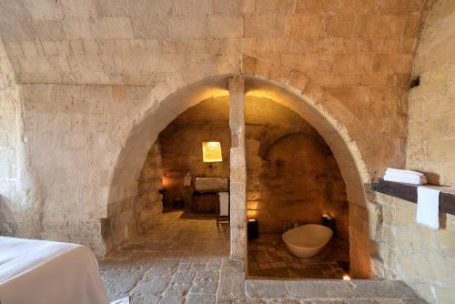 an archway in a stone building with a toilet in it at Sextantio Le Grotte Della Civita in Matera