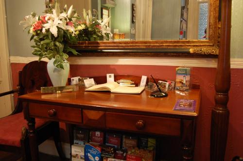 a wooden table with a vase of flowers on top of it at A-Haven Townhouse Hotel in Edinburgh