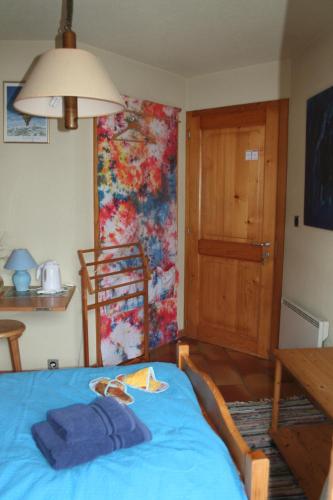 a bedroom with a bed with a blue blanket on it at BnB Claudy et Elizabeth Michellod-Dutheil in Le Châble