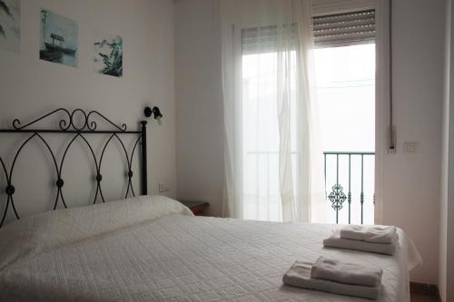 a bedroom with a bed with two towels on it at Easy Nerja Apartments in Nerja
