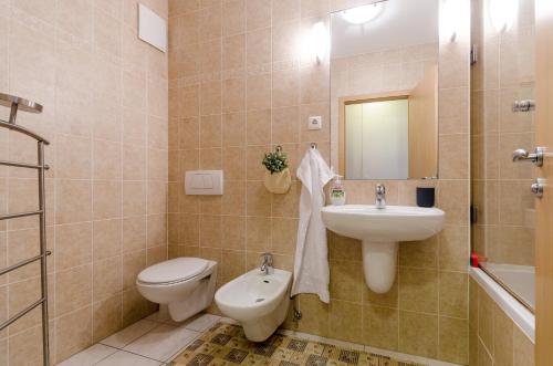 een badkamer met een wastafel, een toilet en een spiegel bij Sweet Home at the Danube with wellness in Boedapest