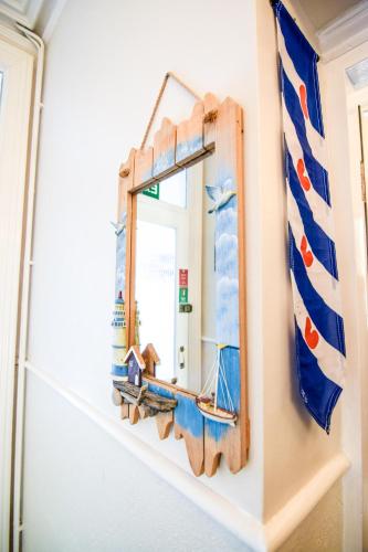 a mirror with a wooden frame on a wall at Eastbourne Reymar in Eastbourne