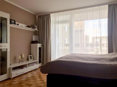 ein Schlafzimmer mit einem Bett und einem großen Fenster in der Unterkunft ProFair Apartments - room agency in Hannover