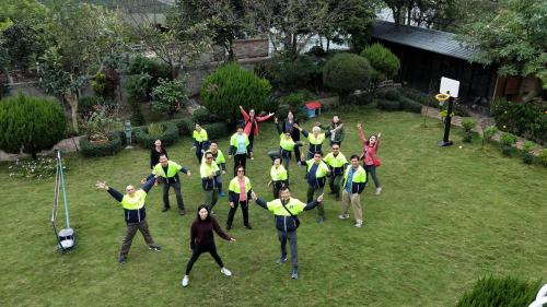 a group of people in yellow vests standing in a yard at Taichung Xinshe Garden Life Homestay B&B in Xinshe