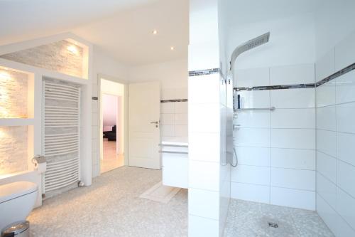 ein Bad mit einer Dusche und einem WC in der Unterkunft ProFair Apartments - room agency in Hannover