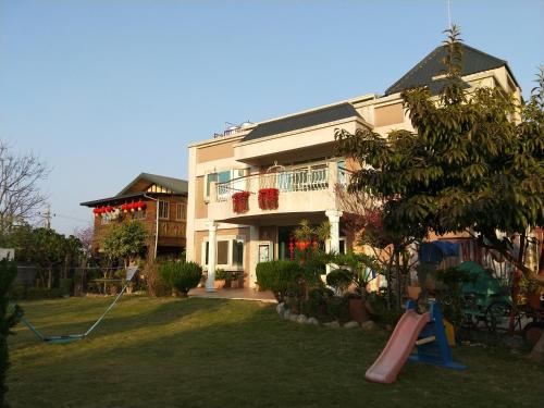 a house with a playground in front of it at Taichung Xinshe Garden Life Homestay B&B in Xinshe