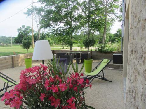 a patio with a table and chairs and flowers at Les terres in Chaponost