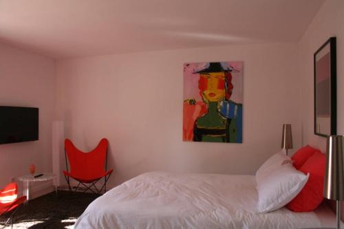a bedroom with a bed and a painting on the wall at Les terres in Chaponost