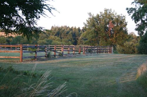 a wooden fence in front of a grass field at Les terres in Chaponost