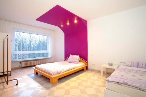 ein Schlafzimmer mit einem Bett und einer lila Decke in der Unterkunft ProFair Apartments near Exhibition Center in Hannover