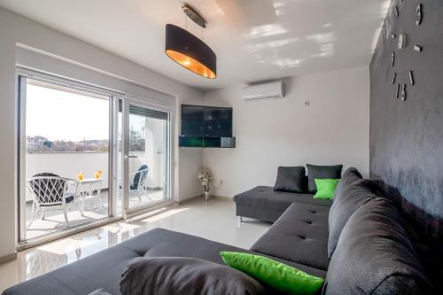 uma sala de estar com um sofá e uma grande janela em Apartments Mira em Pula