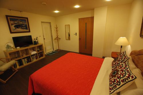 a hotel room with a bed with a red blanket at Taichung Xinshe Garden Life Homestay B&B in Xinshe