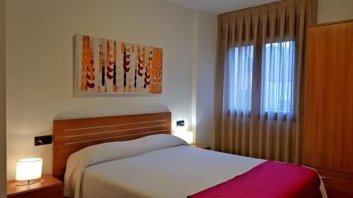Un dormitorio con una cama y una ventana. en Apartamentos Puerta Muralla, en Teruel