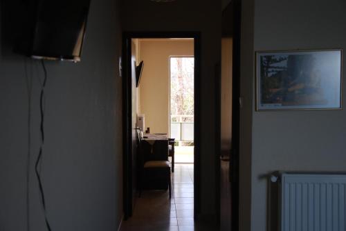 a hallway with a door leading to a room with a chair at Hotel Achillion in Makrýgialos
