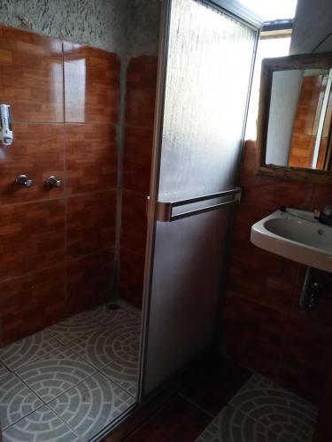 a small bathroom with a shower and a sink at Cabañas Don Camilo Albergue de Montaña in Cabecera de Cañas