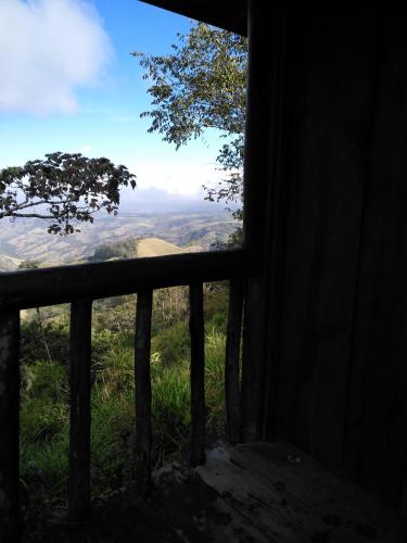 a window looking out at a view of a field at Cabañas Don Camilo Albergue de Montaña in Cabecera de Cañas