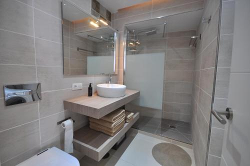 a bathroom with a sink and a toilet and a mirror at Las Vistas Sunset Sea View in Arona