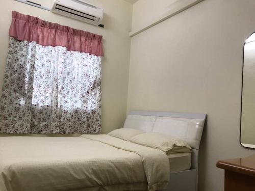 a small bedroom with a bed and a window at Carols Guesthouse near Jonker and Satay Celup in Malacca