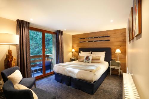 a bedroom with a large bed and a window at La Mainaz Hôtel Restaurant Genève - Gex - Mijoux in Gex
