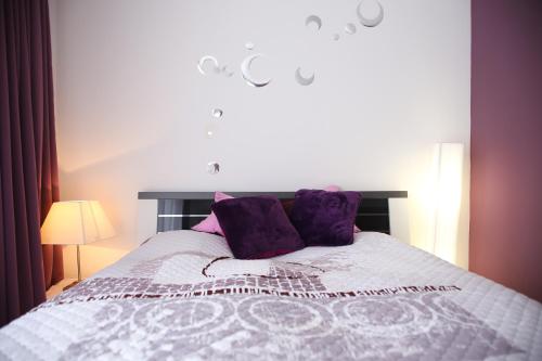 ヘーヴィーズにあるLila Apartmanのベッドルーム1室(大型ベッド1台、紫色の枕付)