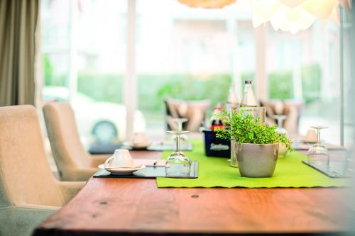 a wooden table with a green napkin and glasses on it at City Hotel Bosse in Bad Oeynhausen