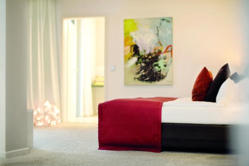 a bedroom with a red and white bed with pillows at City Hotel Bosse in Bad Oeynhausen