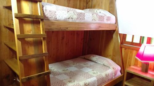 two bunk beds in a room with a lamp at Cabañas Tornagaleones Villarrica in Villarrica