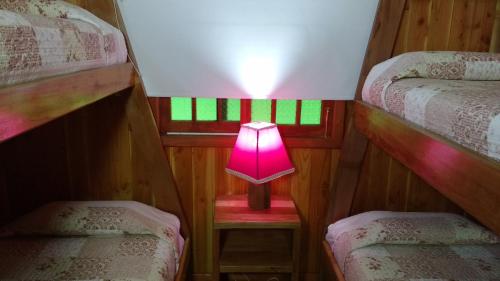 a small pink lamp in a room with two bunk beds at Cabañas Tornagaleones Villarrica in Villarrica