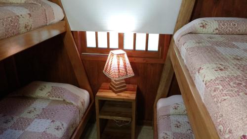 a small room with two bunk beds and a lamp at Cabañas Tornagaleones Villarrica in Villarrica