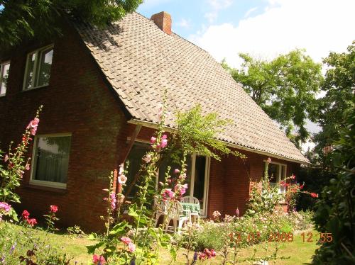 een stenen huis met een stoel in de tuin bij Haus Ebeling in Norderney