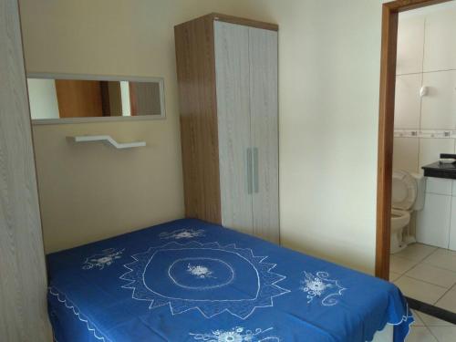 um quarto com uma cama com um edredão azul em Aconchego no Paraíso em Arraial do Cabo