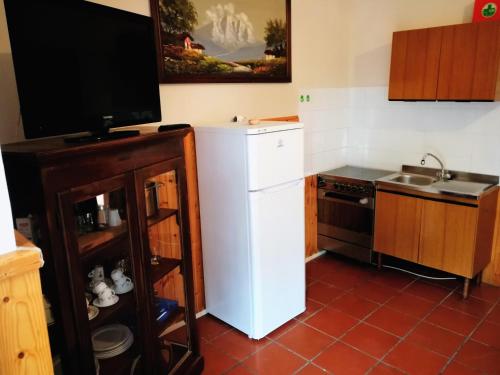 a kitchen with a white refrigerator and a tv at Agriturismo Longetti in Assisi
