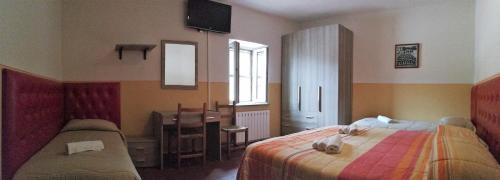 a bedroom with a bed and a desk and a table at Agriturismo Longetti in Assisi