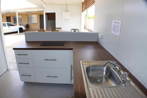a kitchen with a sink and a counter at Baths Motel Moree in Moree