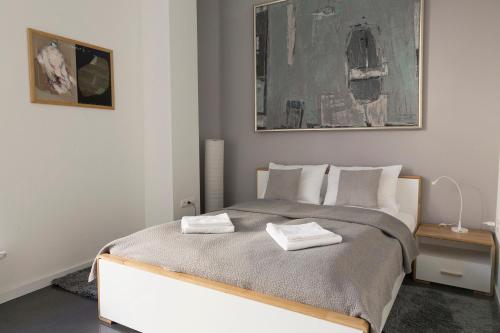 a bedroom with a bed with two towels on it at Art Room Boutique Apartment in Krakow