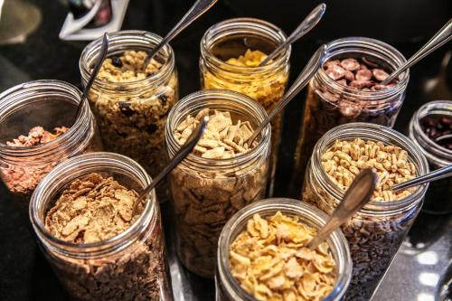 a group of jars filled with different types of granola at arte Hotel Wien Stadthalle in Vienna