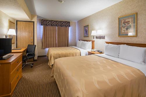 Travelodge by Wyndham Rapid City - Black Hills tesisinde bir odada yatak veya yataklar